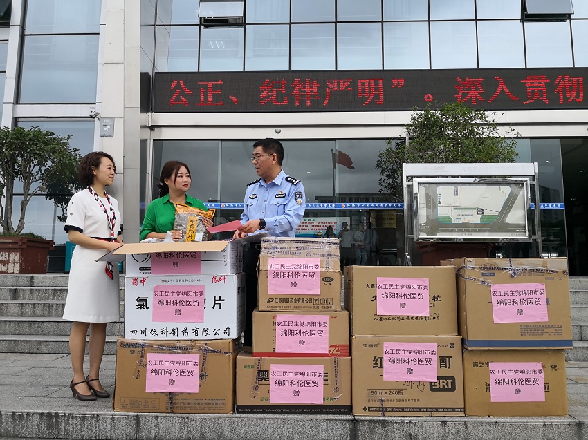 农工党市委委员、科伦医药公司总经理马晓晖（右），农工党市委议政调研科科长肖敏向绵阳交警捐赠物资.jpg