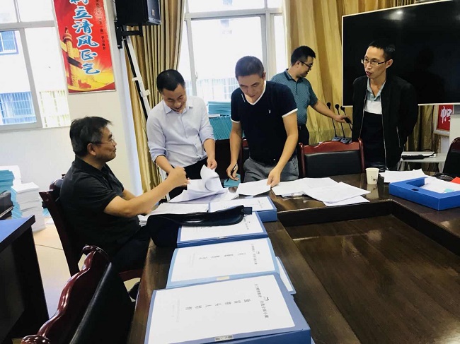 1农工党四川省委秘书长荆小庆查阅脱贫攻坚资料.jpg