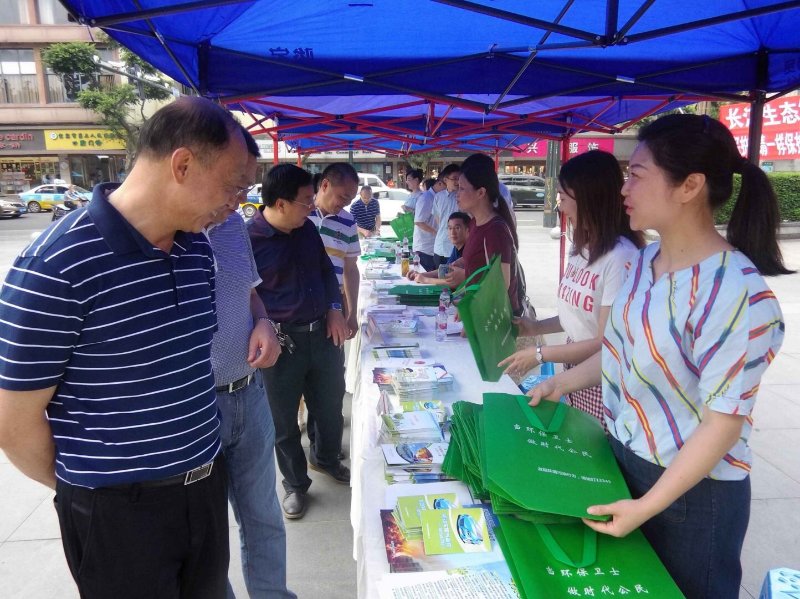 机关干部向市民发放宣传手册和环保袋.jpg