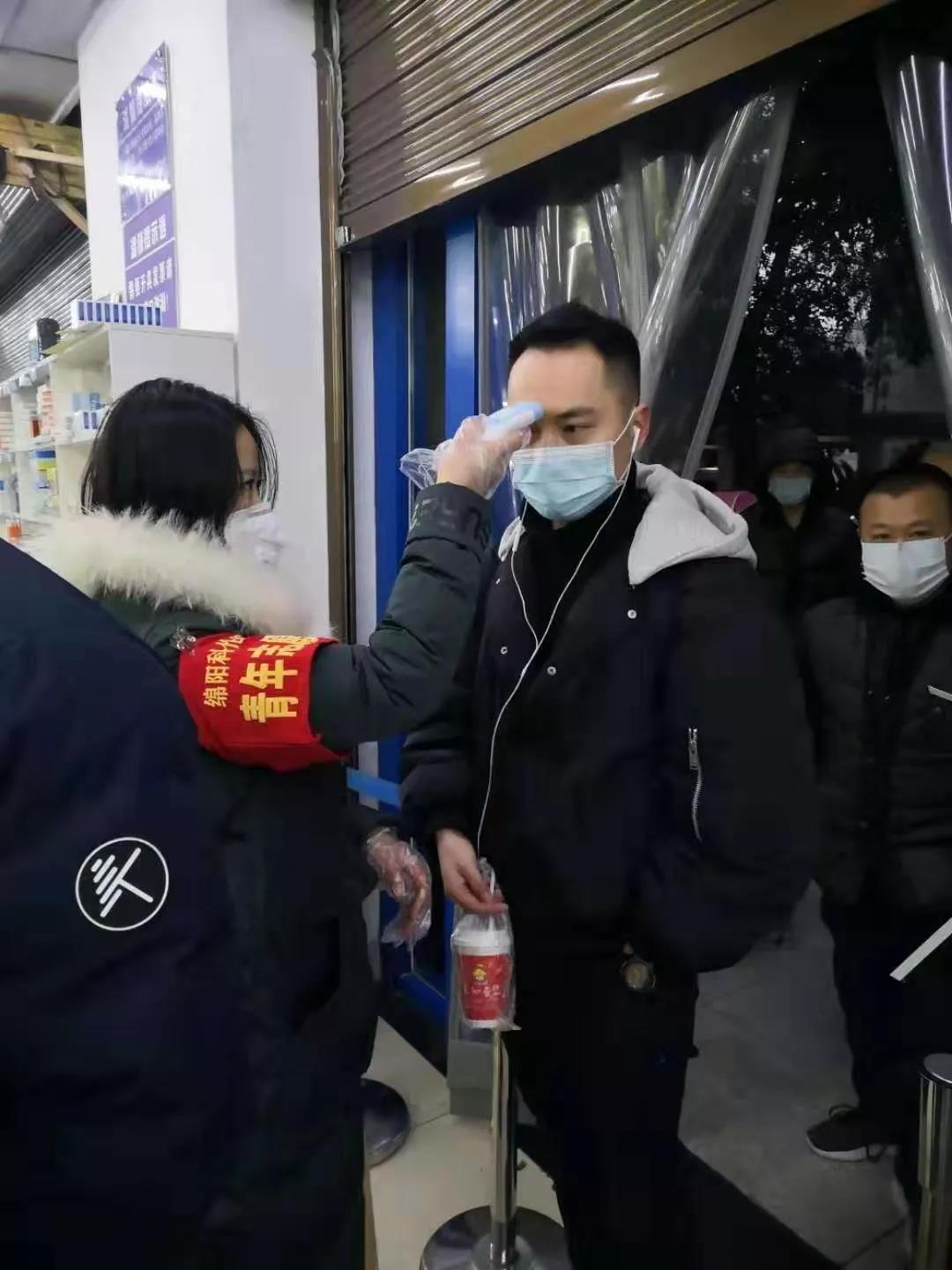 为前来购买口罩的群众测量体温.jpg