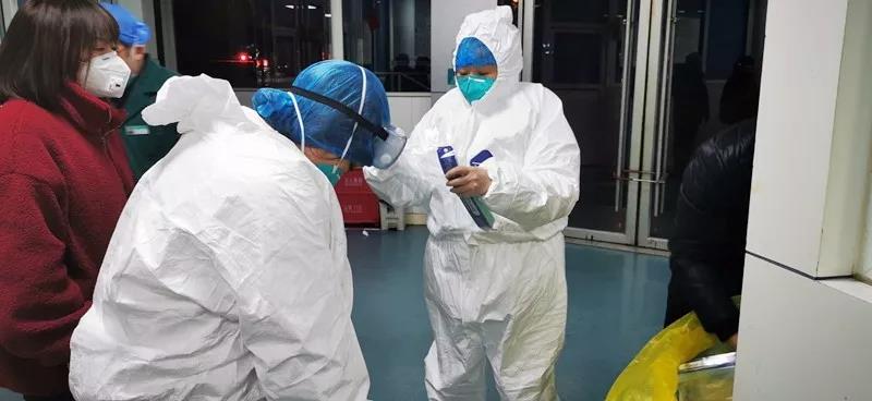 刘宗莉（右一）正在帮同事穿防护服.jpg
