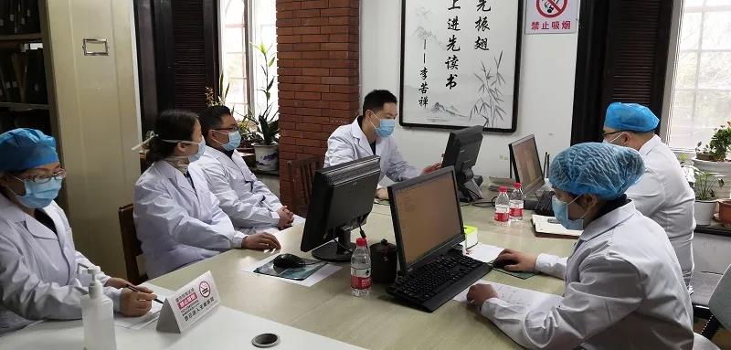 王德明和同事们一起商定防护用品穿脱流程.jpg