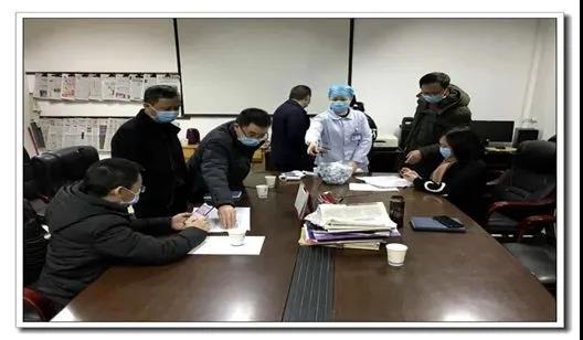 李培彦（右一）与相关科室负责人共同安排人员轮班.jpg